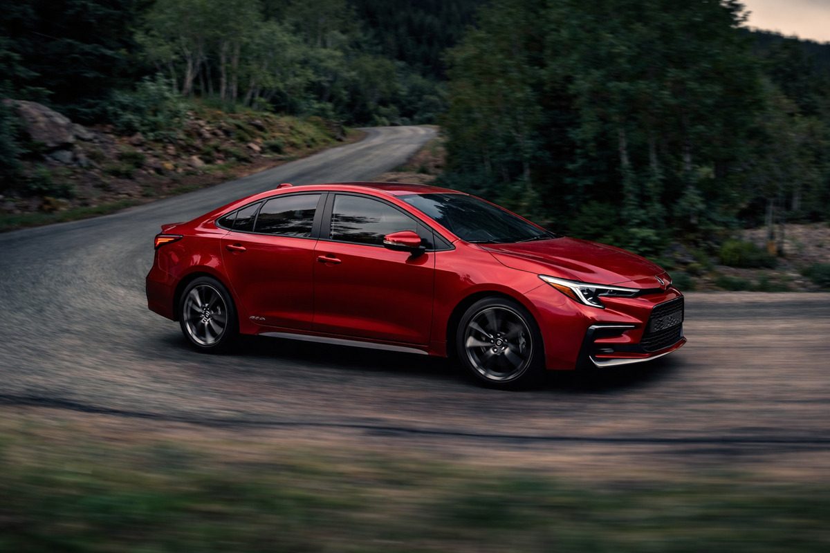 Червена Toyota Corolla седан в движение по горски път